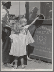 Little girls getting tickets for the merry-go-round at the carnival on the Fourth of July. Vale, Oregon