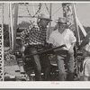 Farm boys getting on the ferris wheel, one of the attractions at the Fourth of July celebration at Vale, Oregon