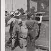 Farm boys buy tickets for ride at the carnival on the Fourth of July. Vale, Oregon