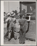 Farm boys buy tickets for ride at the carnival on the Fourth of July. Vale, Oregon