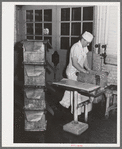 Lining tub with oiled paper before packing butter into it. Dairymen's Cooperative Creamery. Caldwell, Canyon County, Idaho