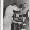 Taking a sample of milk to determine butter fat content. Dairymen's Cooperative Creamery. Caldwell, Canyon County, Idaho