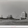 Wheat elevators, sack warehouse and railroad cars. Craigmont, Idaho. Some of these are new elevators--all old elevators were full before the harvest started. All government-owned wheat was being shipped out to make room for the newly harvested crop