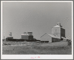 Wheat elevators, sack warehouse and railroad cars. Craigmont, Idaho. Some of these are new elevators--all old elevators were full before the harvest started. All government-owned wheat was being shipped out to make room for the newly harvested crop