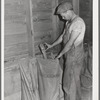 Elevator attendant putting sample of wheat into sacks. Elevator at Eureka, Walla Walla County, Washington