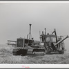 Caterpillar tractor and combine in wheat field on Eureka Flats. Walla Walla County, Washington