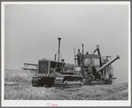 Caterpillar tractor and combine in wheat field on Eureka Flats. Walla Walla County, Washington