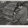 Repairing caterpillar tractor in repair shop at Colfax, Washington