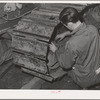 Repairing caterpillar tractor in repair shop at Colfax, Washington