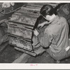 Repairing caterpillar tractor in repair shop at Colfax, Washington