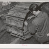 Repairing caterpillar tractor in repair shop at Colfax, Washington