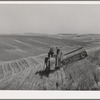 Combine in the wheat. Whitman County, Washington. About ninety percent of the land in this county is under cultivation. Wheat and livestock are principal crops