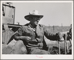 Driver of caterpillar tractor which draws combine in wheat fields of Whitman County, Washington