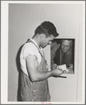 Farm worker getting mail at the FSA (Farm Security Administration) farm family migratory labor camp. Yakima, Washington. At this camp the post office was combined with the Washington State employment service office and in this way the state employment