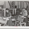 Farm worker practicing wrapping apples in the apple wrapping school at the FSA (Farm Security Administration) farm family migratory labor camp. Yakima, Washington