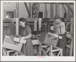 Farm worker practicing wrapping apples in the apple wrapping school at the FSA (Farm Security Administration) farm family migratory labor camp. Yakima, Washington