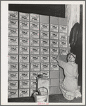 Putting labels on cases of canned salmon at the Columbia River Packing Association. Astoria, Oregon. This plant put up more than 125,000 cases of salmon in the first five days of the phenomenal salmon run this fall