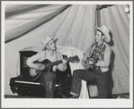 Singing cowboy songs at entertainment at the FSA (Farm Security Administration) mobile camp for migratory farm workers. Odell, Oregon