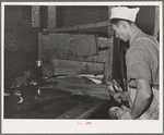 Salmon butcher. Columbia River Packing Association, Astoria, Oregon. During the peak of the run there were 150 butchers working in this plant. Townspeople, CCC (Civilian Conservation Corps) boys, and furloughed soldiers helped out