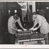 Putting cans of salmon in trays before placing in ovens, where they will be cooked one and a half hours. Columbia River Packing Association, Astoria, Oregon