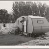 Workman at Umatilla ordnance depot and his children in homemade trailer. Stanfield, Oregon