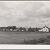 Trailers and other forms of temporary housing for workmen at the Umatilla ordnance depot ground near a farmhouse. Hermiston, Oregon. Workmen at the depot established temporary housing near sources of water