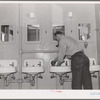 Workman at Navy shipyards, Bremerton, Washington, in the washroom at the FSA (Farm Security Administration) dormitories