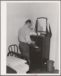 Workman at the Navy shipyards, Bremerton, Washington, in his room at the FSA (Farm Security Administration) duration dormitories. Bremerton, Washington