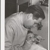 FSA (Farm Security Administration) dentist and migrant child in the FSA dental trailer at the FSA camp for farm families, Caldwell, Idaho