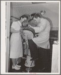 FSA (Farm Security Administration) dentist and nurse with migrant child in the FSA dental trailer at the FSA camp for farm families. Caldwell, Idaho