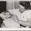 FSA (Farm Security Administration) nurse examines the teeth of migrant in the FSA dental trailer at the FSA camp for farm workers. Caldwell, Idaho