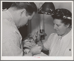 FSA (Farm Security Administration) dentist and nurse and migrant child in the FSA dental trailer at the FSA camp for farm families. Caldwell, Idaho