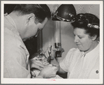 FSA (Farm Security Administration) dentist and nurse and migrant child in the FSA dental trailer at the FSA camp for farm families. Caldwell, Idaho