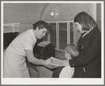 Two migrant children register with the nurse in the FSA (Farm Security Administration) dental trailer while it is parked at the FSA camp for farm families. Caldwell, Idaho