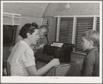 The FSA (Farm Security Administration) nurse types out dental record of migrant child in the dental trailer while at the FSA camp for farm workers. Caldwell, Idaho