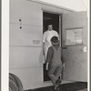 The FSA (Farm Security Administration) nurse welcomes migrant boy to FSA dental trailer at the FSA camp for farm families. Caldwell, Idaho