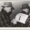 Putting number on a gleaner's back. Cornhusking contest, Ontario, Oregon. The gleaner's job is to follow the husker with corresponding numbers and gather the ears missed by husker and also ears picked but which miss the wagon