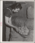 Mrs. Lee Wagoner, wife of Black Canyon Project farmer, gets homegrown potatoes from storeroom. Canyon County, Idaho