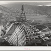 Shasta Dam under construction. Cable cars carrying materials operate from the high tower. Shasta County, California