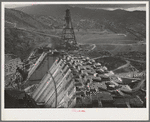 Shasta Dam under construction. Cable cars carrying materials operate from the high tower. Shasta County, California