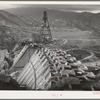 Shasta Dam under construction. Cable cars carrying materials operate from the high tower. Shasta County, California