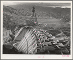 Shasta Dam under construction. Cable cars carrying materials operate from the high tower. Shasta County, California