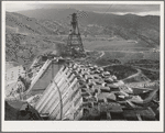 Shasta Dam under construction. Cable cars carrying materials operate from the high tower. Shasta County, California