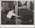 Hydraulic pressure is applied to bags of crushed olives to force out the oil. The first pressing extracts about seventy-five percent of the entire oil content. This is fine virgin olive oil. Lindsay, California