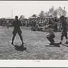 Boys from nearby Army camp play baseball at the field day at the FSA (Farm Security Administration) farm workers' community. Yuma, Arizona