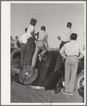 Farm workers watch athletic events at the second annual field day at the FSA (Farm Security Administration) farm workers' community. Yuma, Arizona