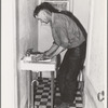 Ola, Idaho. A member of the Ola self-help cooperative in the bathroom, a recent improvement in his home of which he is proud