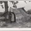 Daughter of agricultural day laborer coming out of tent where her uncle slept. Poteau Creek near Spiro, Oklahoma