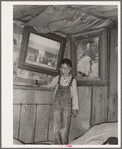 Indian boy between portraits of his ancestors. Near Sallisaw, Oklahoma