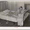 Daughter of woman tenant farmer reading magazine. Near Sallisaw, Oklahoma